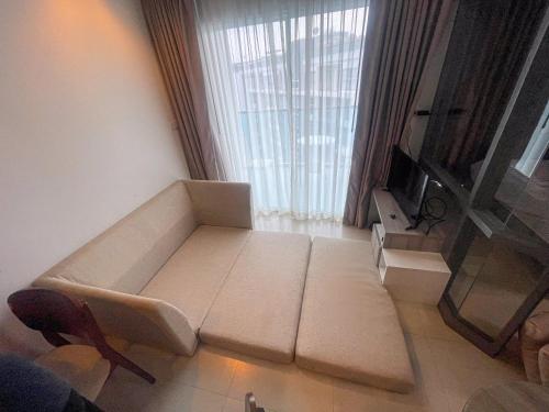 a living room with a couch in front of a window at GB710 Grand Blue Beach Condo maephimholiday in Klaeng