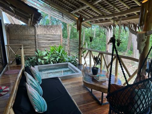 a screened in porch with a hammock and a swimming pool at Carabao Lodge - 2 bedroom house with AC & plunge pool in El Nido