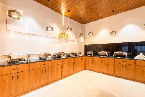 a kitchen with wooden cabinets and a counter with pots and pans at DLS Divine River Resort and Spa, Rishikesh in Rishīkesh