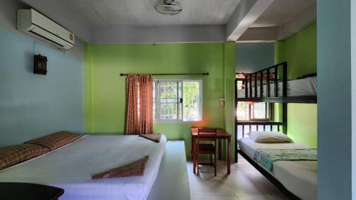 Postel nebo postele na pokoji v ubytování Sarin Guesthouse สาริน