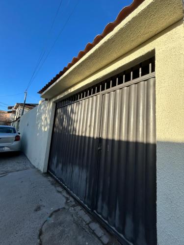 a metal gate on the side of a building at Casa alegria 15 min do toa toa in Porto Seguro