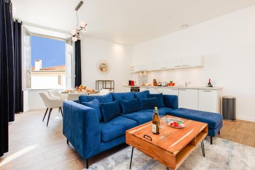 un salon avec un canapé bleu et une table dans l'établissement Villa Californie, à Cannes