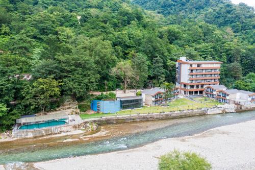 an aerial view of a building next to a river at DLS Divine River Resort and Spa, Rishikesh in Rishīkesh