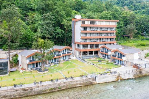 an aerial view of a building next to the water at DLS Divine River Resort and Spa, Rishikesh in Rishīkesh