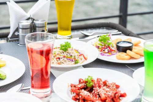 a table with plates of food and drinks on it at DLS Divine River Resort and Spa, Rishikesh in Rishīkesh