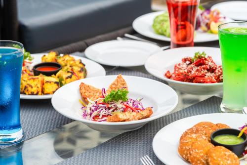 a table topped with plates of food and drinks at DLS Divine River Resort and Spa, Rishikesh in Rishīkesh