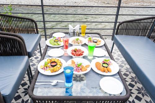 a table with plates of food and drinks on it at DLS Divine River Resort and Spa, Rishikesh in Rishīkesh