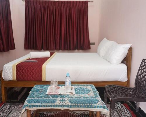 a hotel room with a bed and a table with a table sidx sidx at RD Resort in Pondicherry