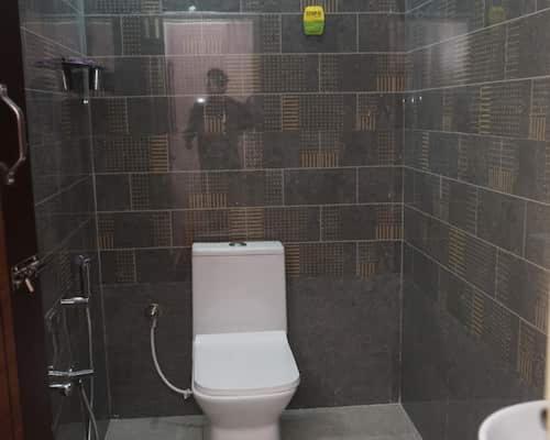 a person taking a picture of a bathroom with a toilet at RD Resort in Pondicherry