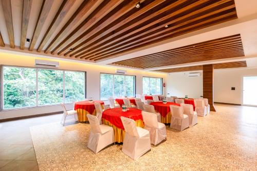 a conference room with red and white tables and chairs at DLS Divine River Resort and Spa, Rishikesh in Rishīkesh