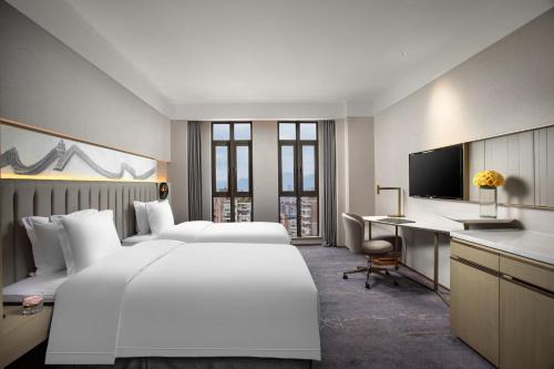 a large hotel room with two beds and a desk at Crowne Plaza Fuzhou South by IHG in Fuzhou