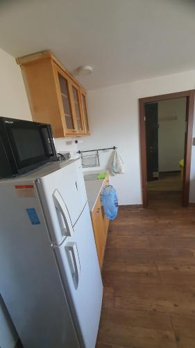 a kitchen with a refrigerator and a wooden floor at ורד אירוח in Eilat