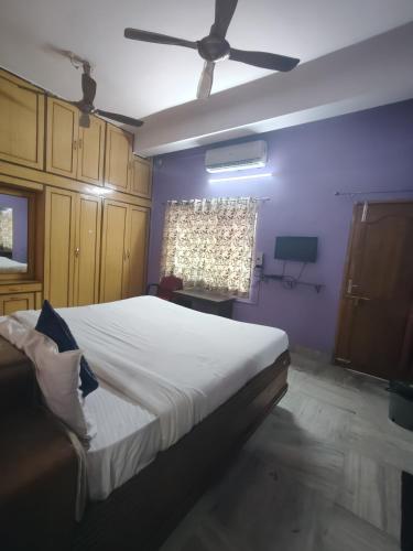 a bedroom with a bed and a ceiling fan at Hotel Sai Ram Plaza in Bhubaneshwar