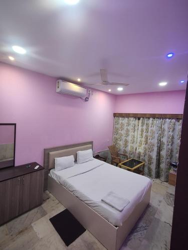 a bedroom with a large bed and a television at Hotel Sai Ram Plaza in Bhubaneshwar