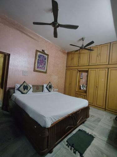 a bedroom with a large bed with a ceiling fan at Hotel Sai Ram Plaza in Bhubaneshwar