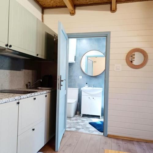 a bathroom with a sink and a toilet and a mirror at Ogrzewane Domki u Kamili Sztutowo, Jacuzzi, plac zabaw, klimatyzacja, parking# 884#90#09#01 in Sztutowo