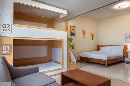 1 dormitorio con litera y sofá en Uptown BGC Spacious Unit - 1 Queen bed and Bunkbed, en Manila