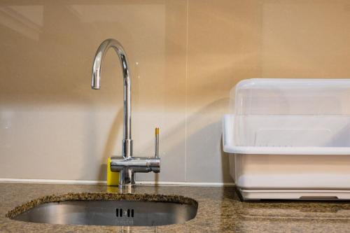 Una encimera de cocina con un fregadero y un fregadero. en Uptown BGC Spacious Unit - 1 Queen bed and Bunkbed, en Manila