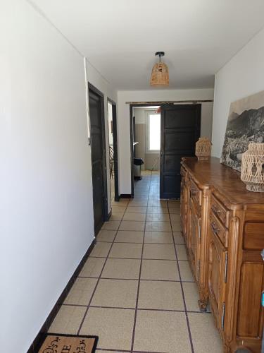 une cuisine avec des armoires en bois et un sol carrelé dans l'établissement Appartement de village avec grande terrasse, à Malaucène