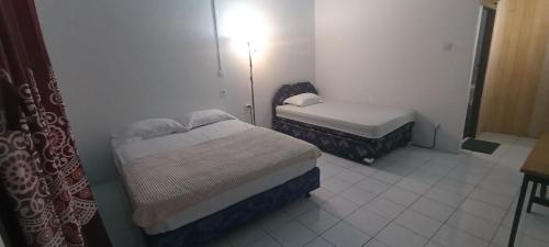 a small bedroom with two beds in a room at MamaRoos Reborn Home Stay in Rinondoran