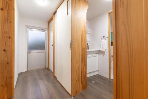a hallway with a door leading to a bathroom at たーちやー in Motobu