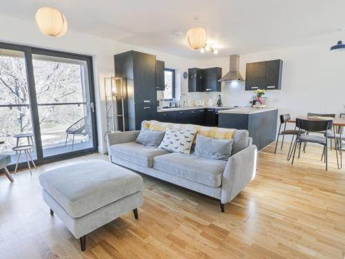 a living room with a couch and a chair and a kitchen at Tay View in Aberfeldy