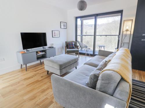 a living room with a couch and a tv at Tay View in Aberfeldy