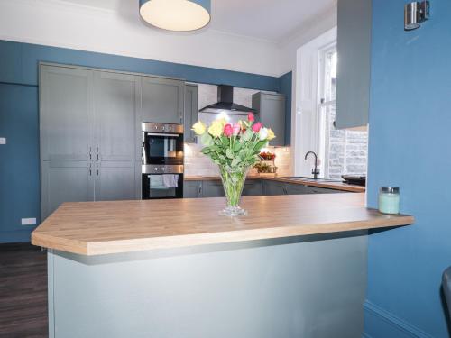 a kitchen with a vase of flowers on a counter at Glenspey in Kingussie