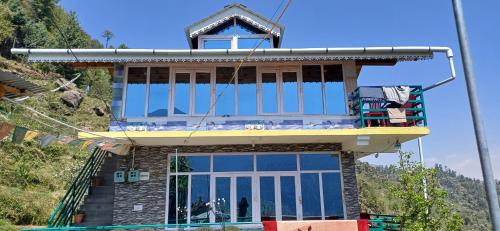 a house with a balcony on top of it at The Shire Snower in Kulu
