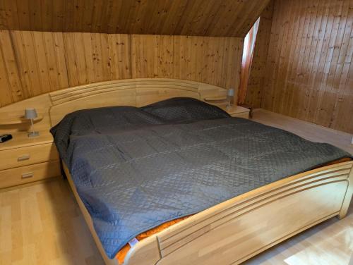 a bedroom with a bed in a wooden room at Haus Bärnstein in Grafenau