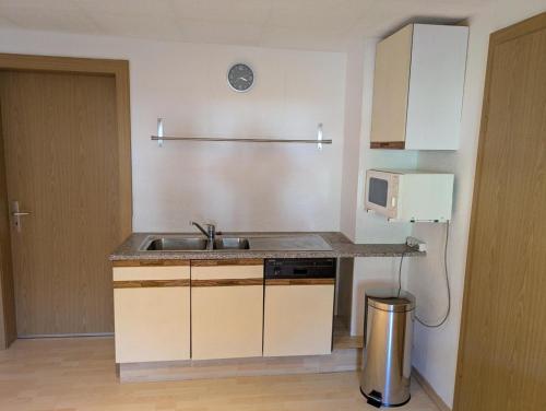 a small kitchen with a sink and a microwave at Haus Bärnstein in Grafenau