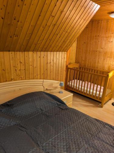 a bedroom with a bed in a wooden cabin at Haus Bärnstein in Grafenau