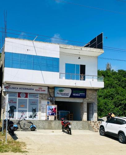 a white building with motorcycles parked in front of it at Apartamento Ciudad del Surf Montañita in Montañita