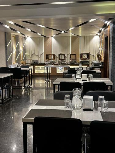 a restaurant with tables and chairs in a room at ROYAL ACE LUXUR in Bengaluru