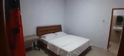 a small bedroom with a bed and a sink at Renny's Tangkoko Safety Stop in Bitung