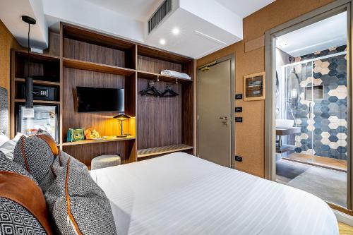 a hotel room with a bed and a tv at Hotel Duomo Firenze in Florence