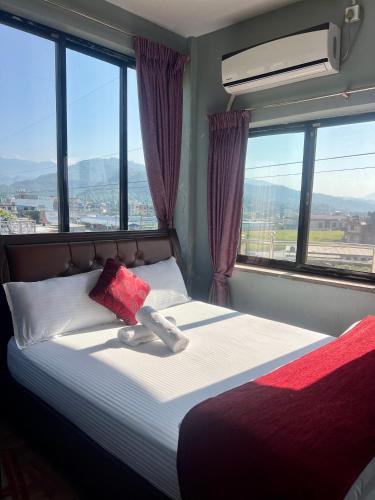 a bedroom with a bed with a large window at Hotel Mina's dream in Pokhara
