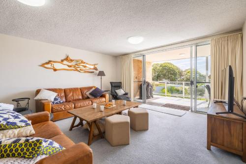 a living room with a couch and a table at Portofino, 1,7 Laman Street - First floor unit with beautiful views, air con and Wi-Fi and close to town in Nelson Bay