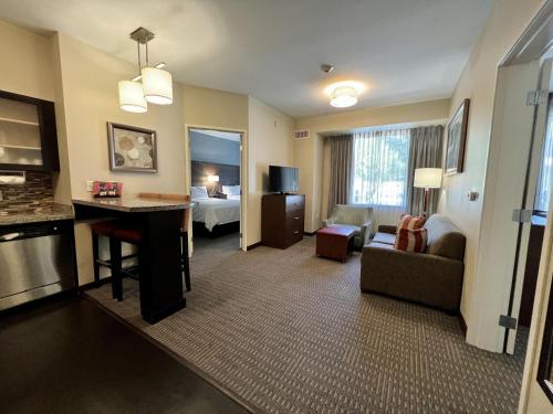 a hotel room with a bed and a living room at Staybridge Suites Carlsbad/San Diego by IHG in Carlsbad