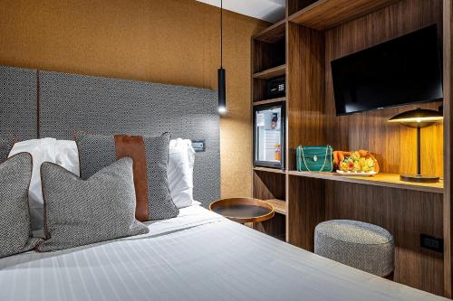 a hotel room with a bed and a tv at Hotel Duomo Firenze in Florence