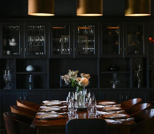 a dining room with a table with plates and glasses at Adelaide Hills luxury cottage spectacular views in Summertown