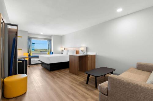 a hotel room with a bed and a couch at Microtel Inn & Suites by Wyndham Tulsa - Catoosa Route 66 in Tulsa