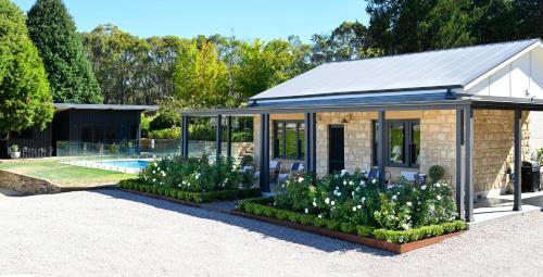 a small greenhouse with flowers in a garden at Adelaide Hills luxury cottage spectacular views in Summertown