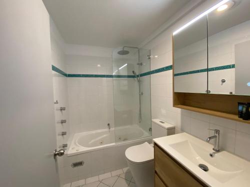 a bathroom with a tub and a toilet and a sink at Three Bears 2 - Thredbo in Thredbo
