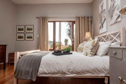 a bedroom with a large white bed with a window at 10onBrightside-Exp the epitome of country living in Nelspruit