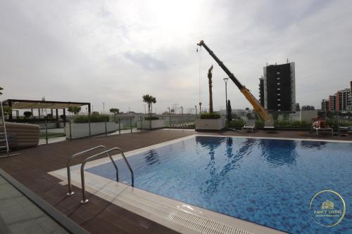 a swimming pool with a crane on top of a building at Luxury 2-BHK Apartment Located in Azizi riviera 47 Riv 47-419 in Dubai