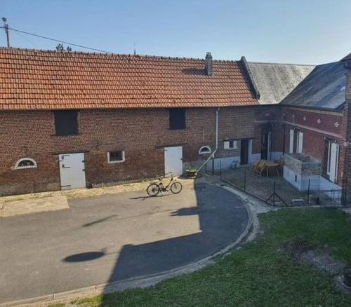 una bicicletta parcheggiata di fronte a un edificio di mattoni di La fermette d'etinehem a Étinehem