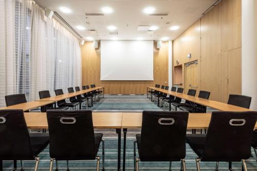 a conference room with tables and chairs and a whiteboard at Hilton Helsinki Airport in Vantaa