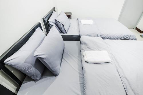 two beds in a room with white sheets and pillows at Don Muang Hotel in Bangkok