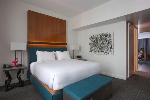 a bedroom with a large white bed with a blue stool at Andaz San Diego, By Hyatt in San Diego